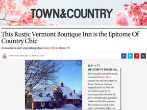Screenshot of a Town & Country article titled This Rustic Vermont Boutique Inn is the Epitome Of Country Chic, showcasing why this snowy inn—framed by tall trees and a blue sky—belongs on any list of 15 reasons to visit Vermont.