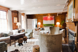 A room with wood paneled walls, a white door, and several packages neatly stacked in the corner.