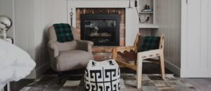 A cozy fireplace with a chair and blanket, reminiscent of the inviting comfort found in Edson Hill Guest Rooms.