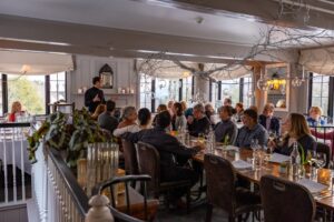 A group of people sitting at a table, gathered together to enjoy Thanksgiving Dinner in Stowe, Vermont.