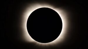 A total solar eclipse, with the dark silhouette of the moon completely covering the sun, offers a breathtaking view—perfect for eclipse travel packages—showcasing the sun’s bright white corona against a dramatic black sky.